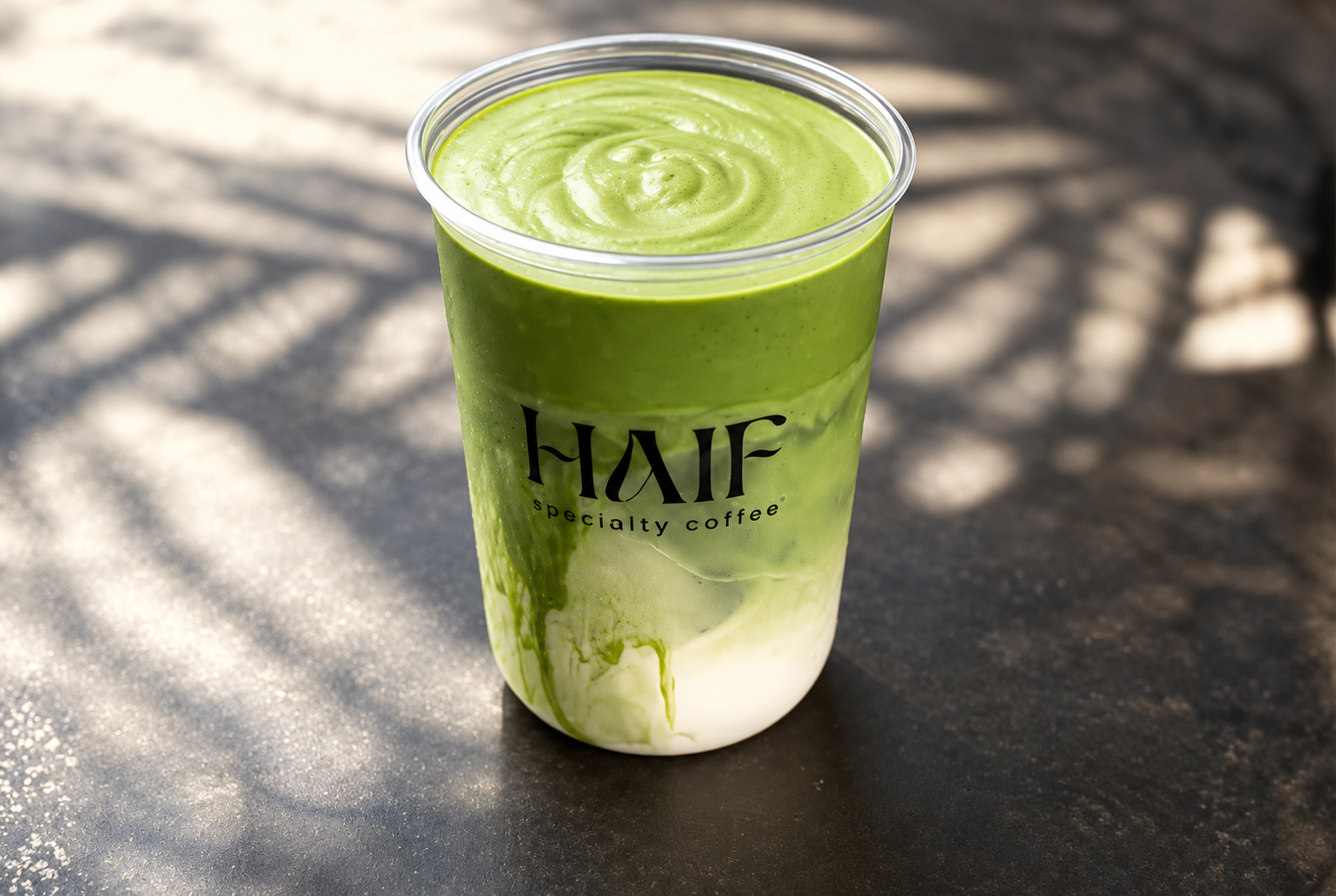 Haif coconut matcha in a clear branded cup